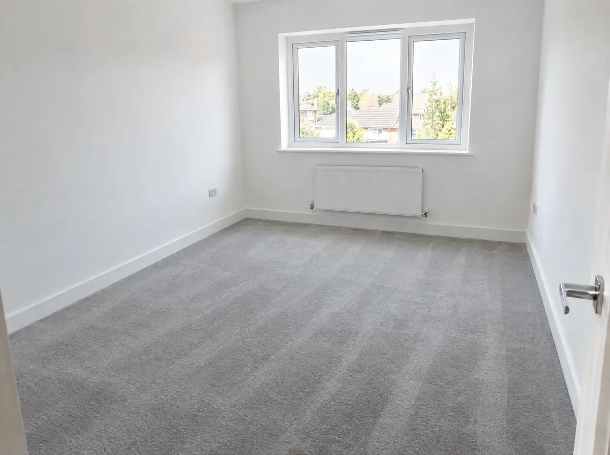 Empty, freshly cleaned rental bedroom with spotless skirting boards and carpet